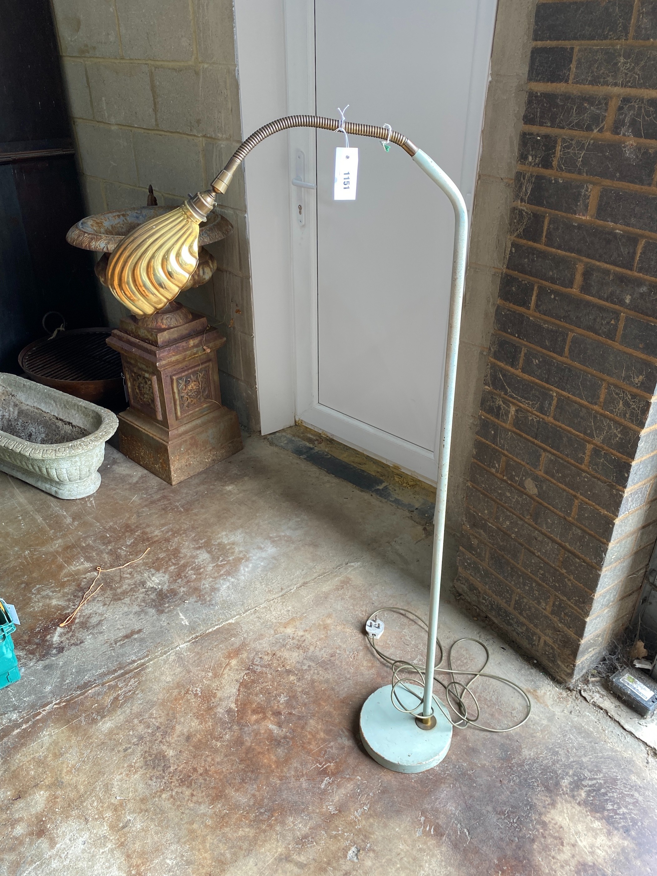 A vintage painted metal floor lamp with brass shade